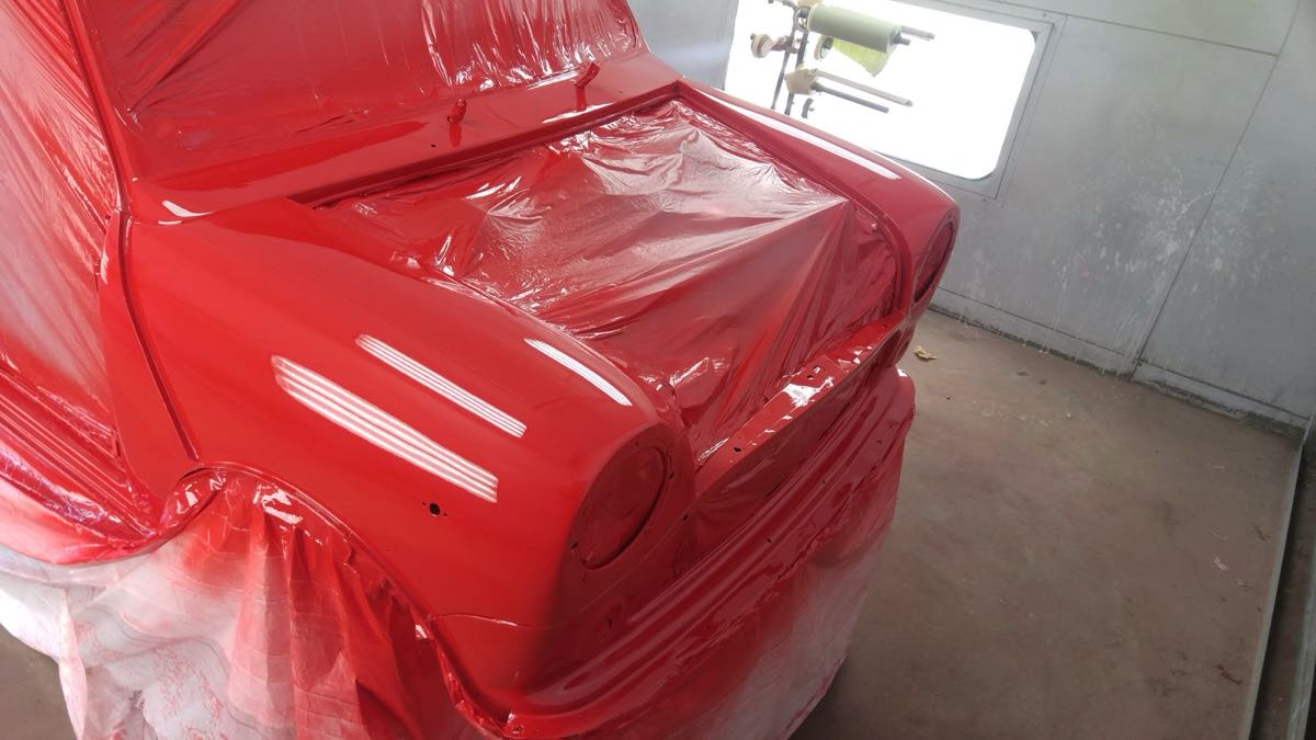 Xe che dán kín, vừa phun xong lớp sơn màu trong buồng sơn